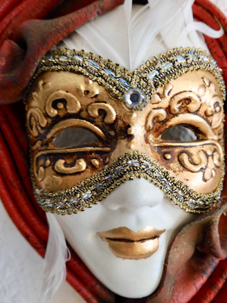 Close-up of a Mahalakshmi face mask adorned with pearls and colorful stones, glowing softly against a warm background.