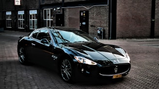 black porsche 911 parked in front of brown brick building
