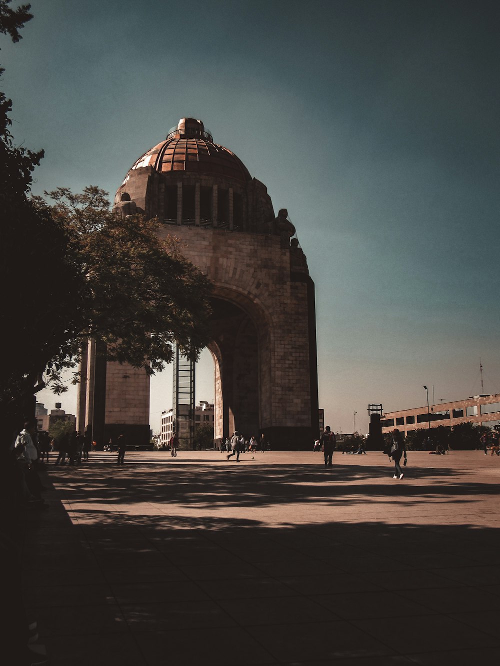 people walking on sidewalk near arch gate during night time