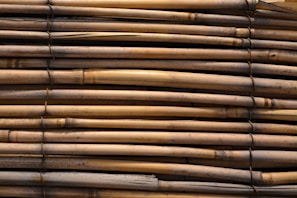 Stack of rolled bamboo chick blinds ready for delivery, showcasing natural textures and colors