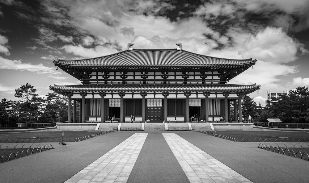 grayscale photo of building under cloudy sky