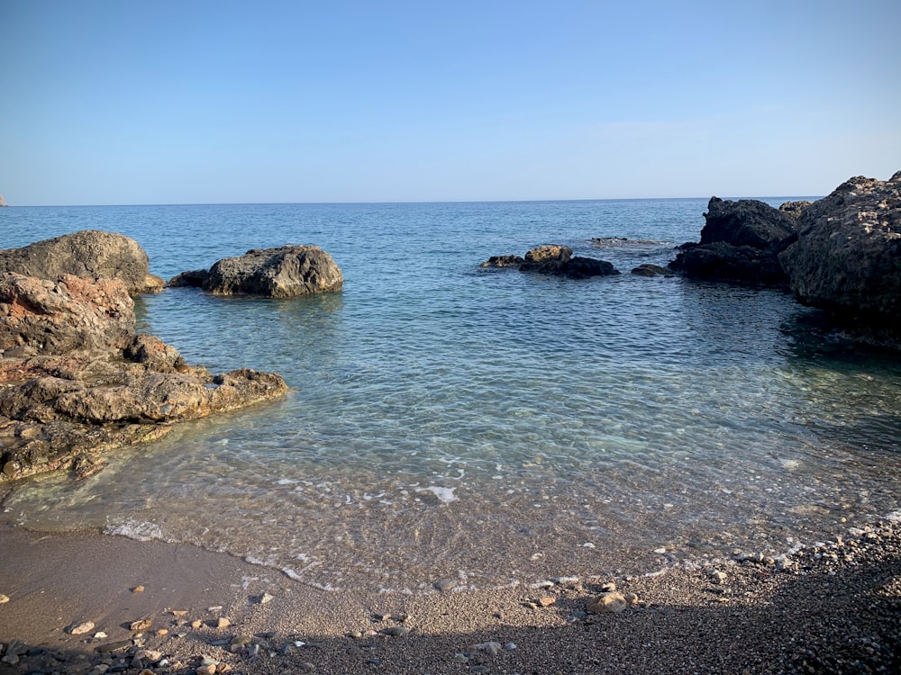 brown rock formation on sea during daytime