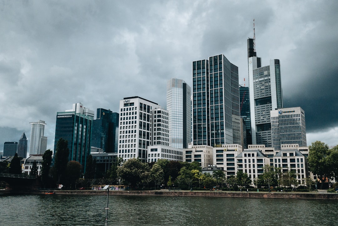 city buildings near body of water under cloudy sky during daytime