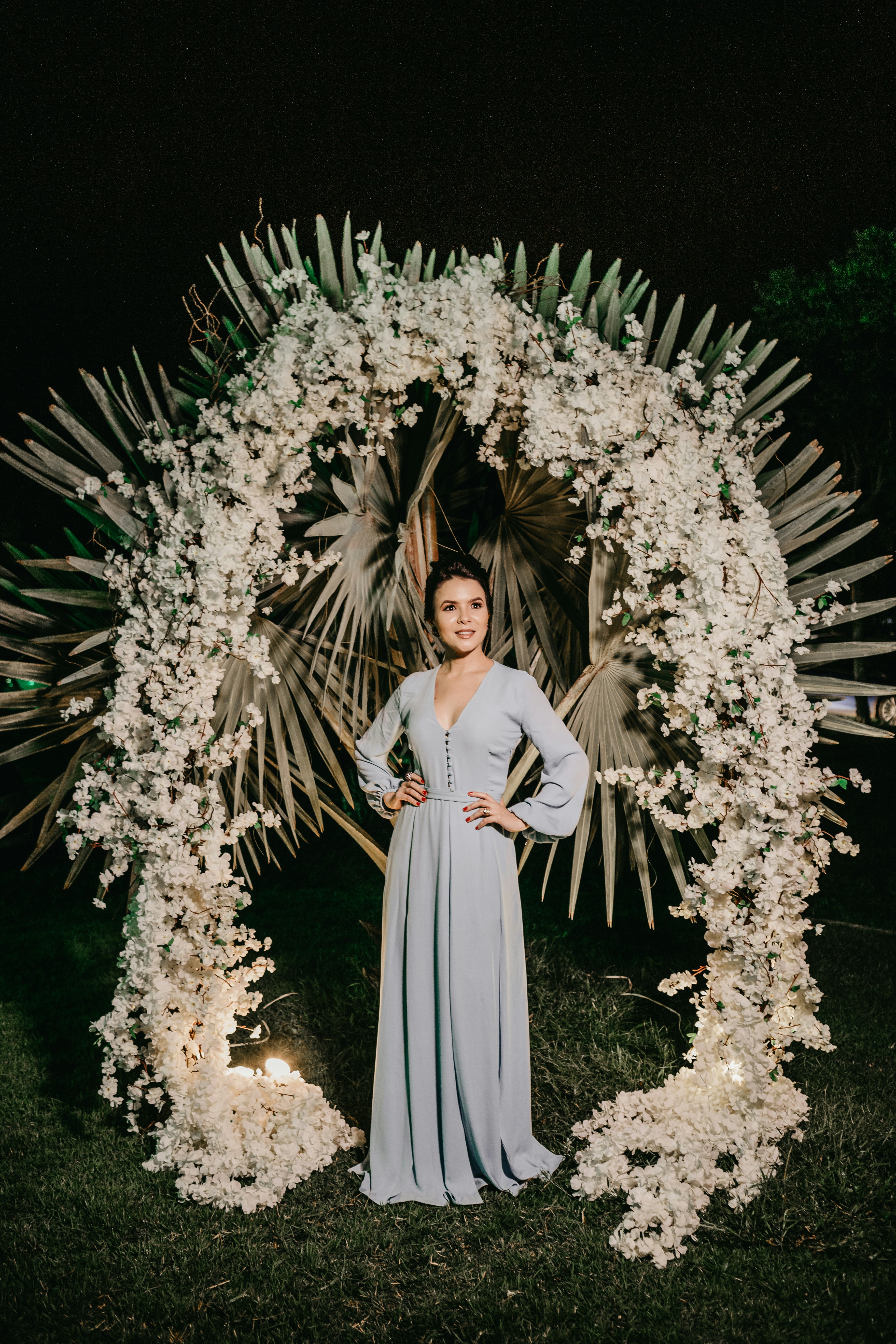 woman in white long sleeve dress standing beside green pine tree