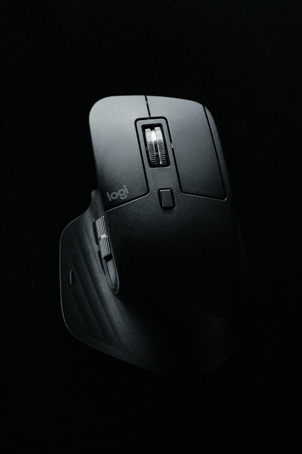 black cordless computer mouse on black mouse pad