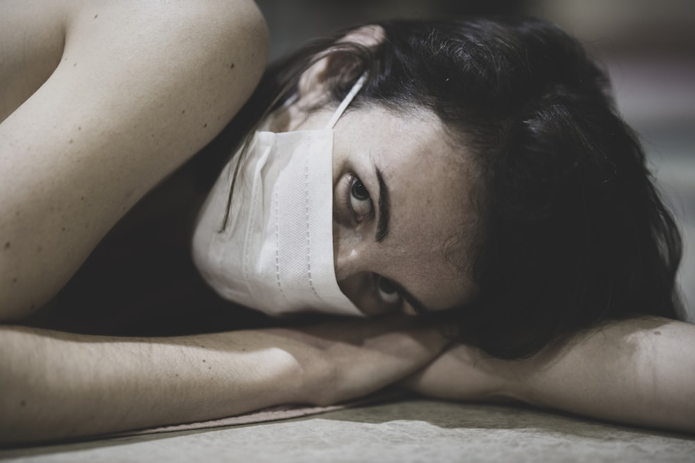 woman lying on white textile