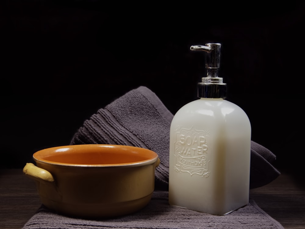 white plastic pump bottle beside yellow ceramic mug