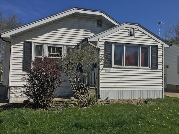 A freshly renovated single-family home with a bright blue door and manicured lawn in Wichita Falls.