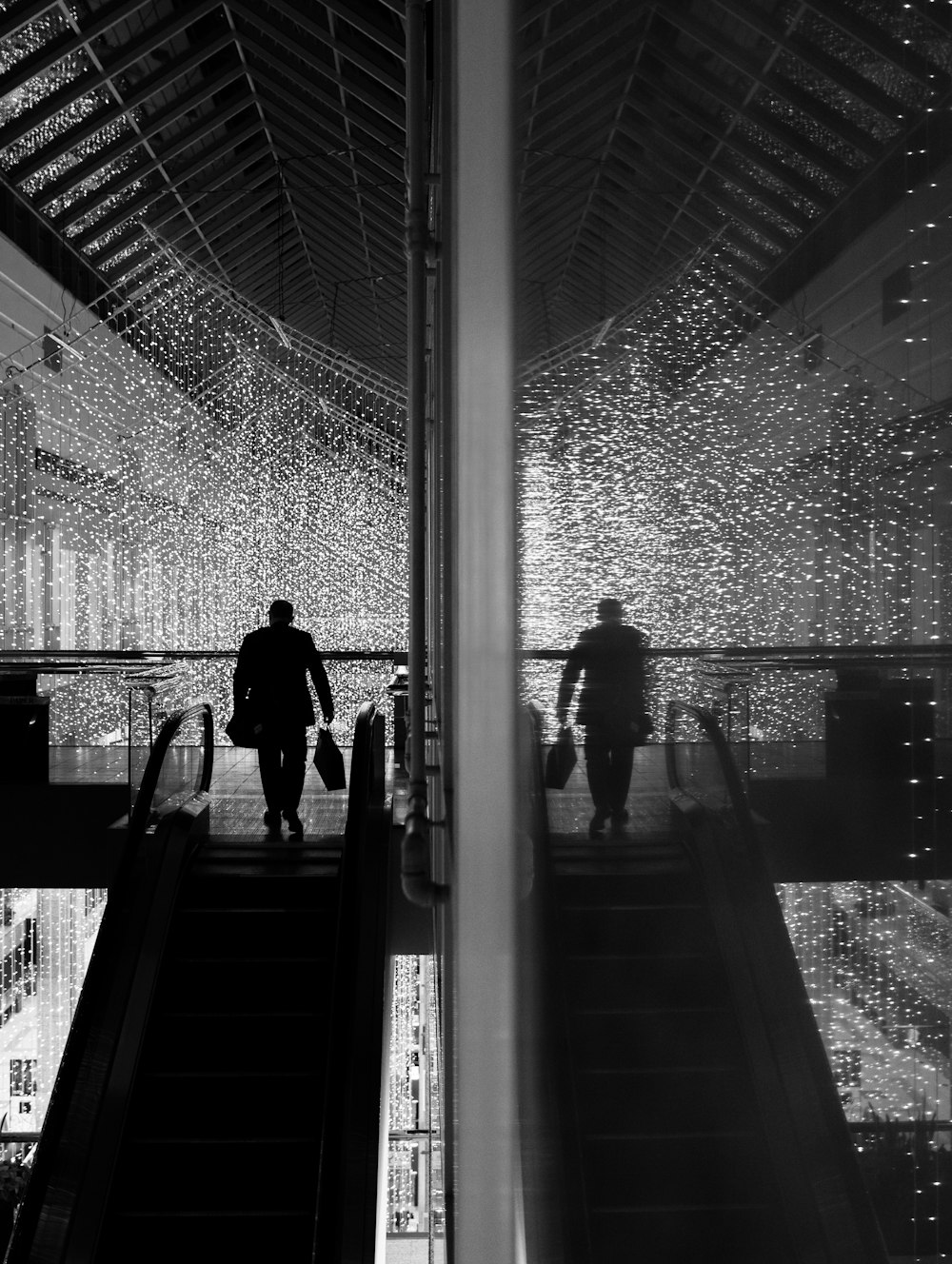 grayscale photo of man and woman walking on staircase