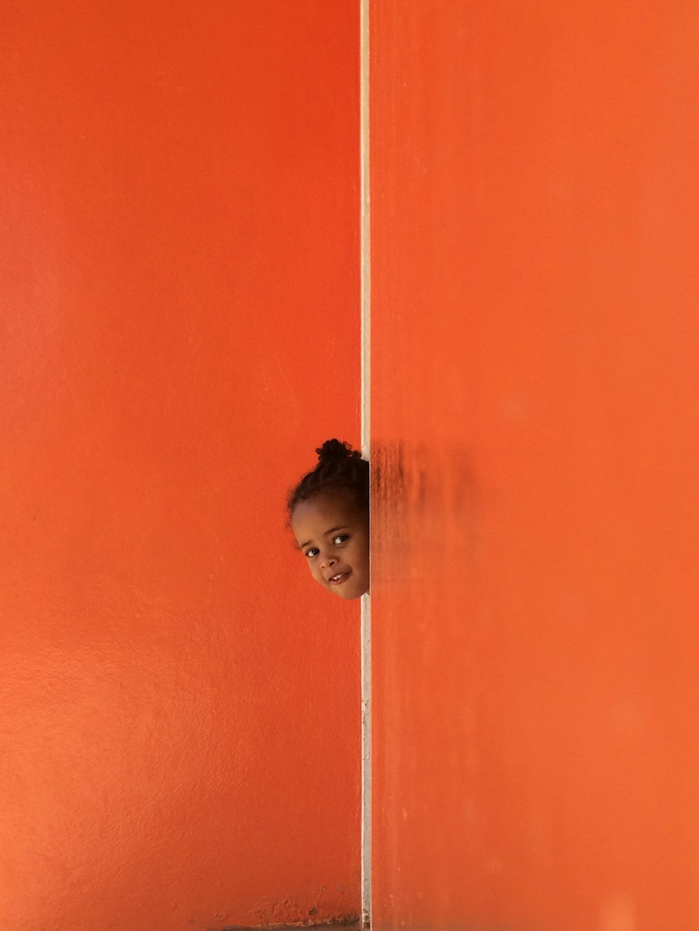 poupée de bébé sur mur orange