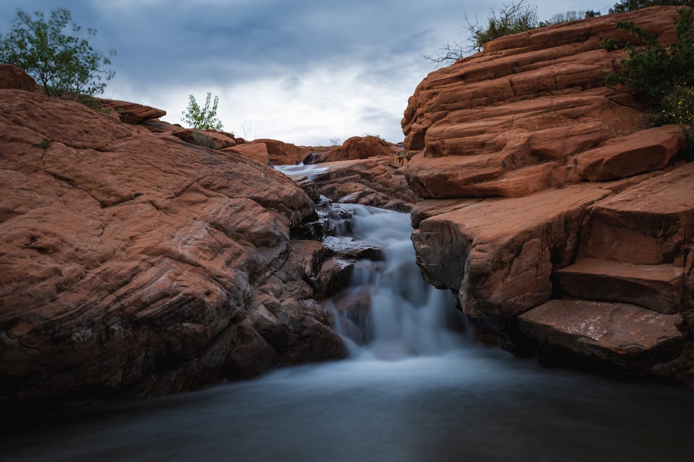 brown rock formation with water falls