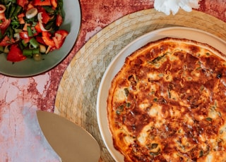 pizza with red and white flowers on brown wooden tray