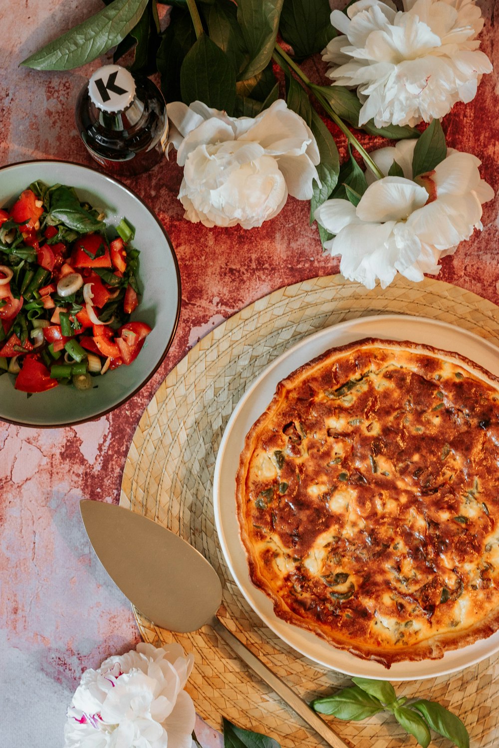 갈색 나무 쟁반에 빨간색과 흰색 꽃이 있는 피자