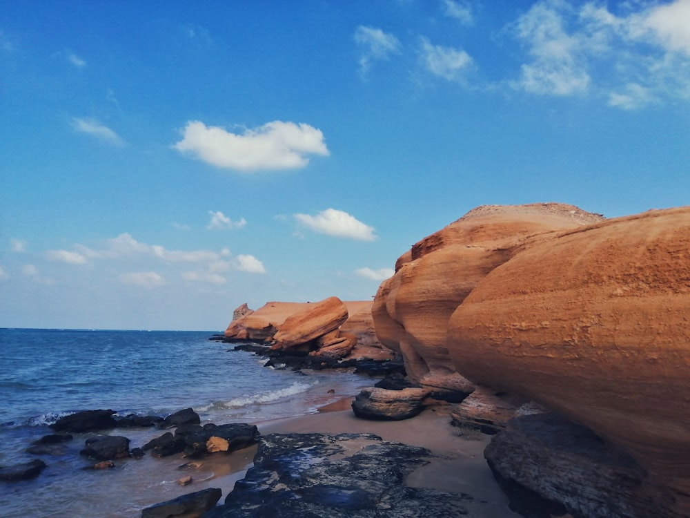 brown rock formation on sea shore during daytime