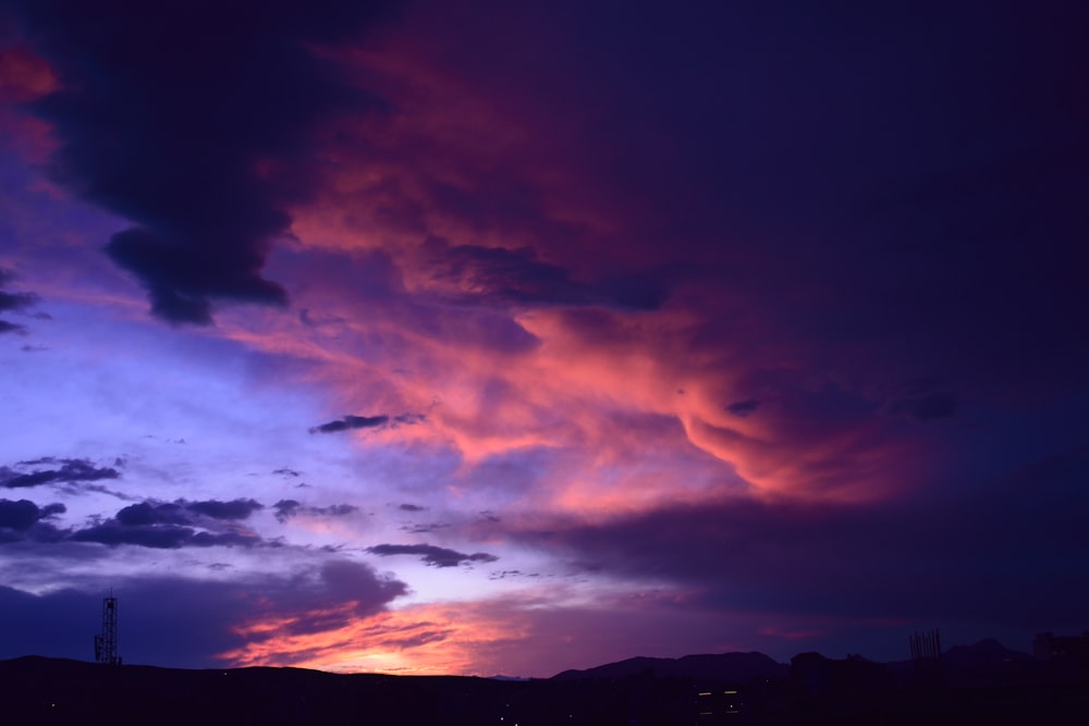 silhouette of mountain under orange and blue cloudy sky during sunset