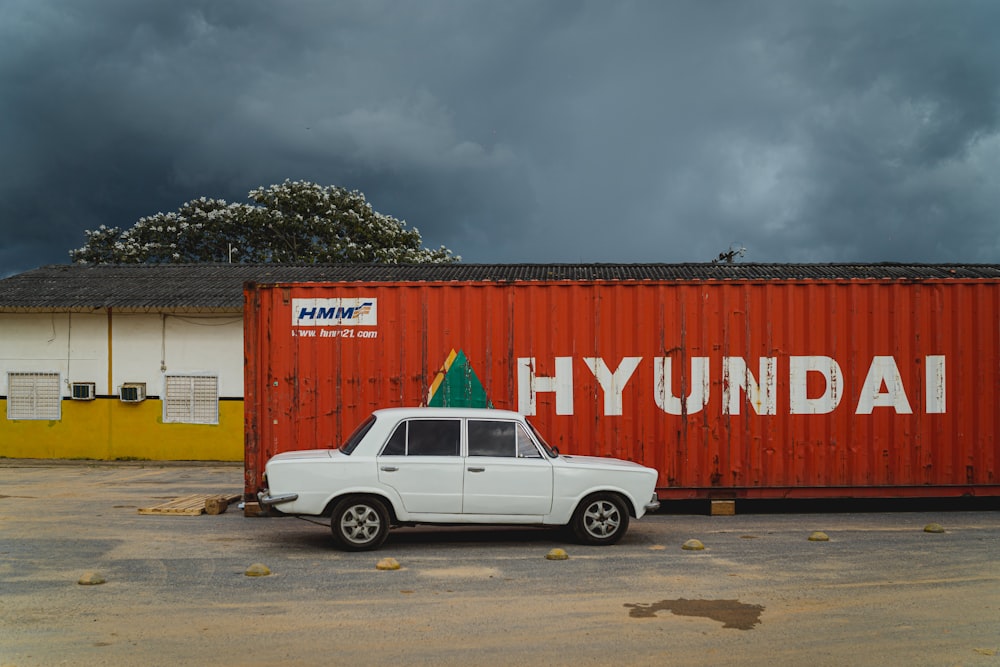 white crew cab pickup truck parked beside red and white wall