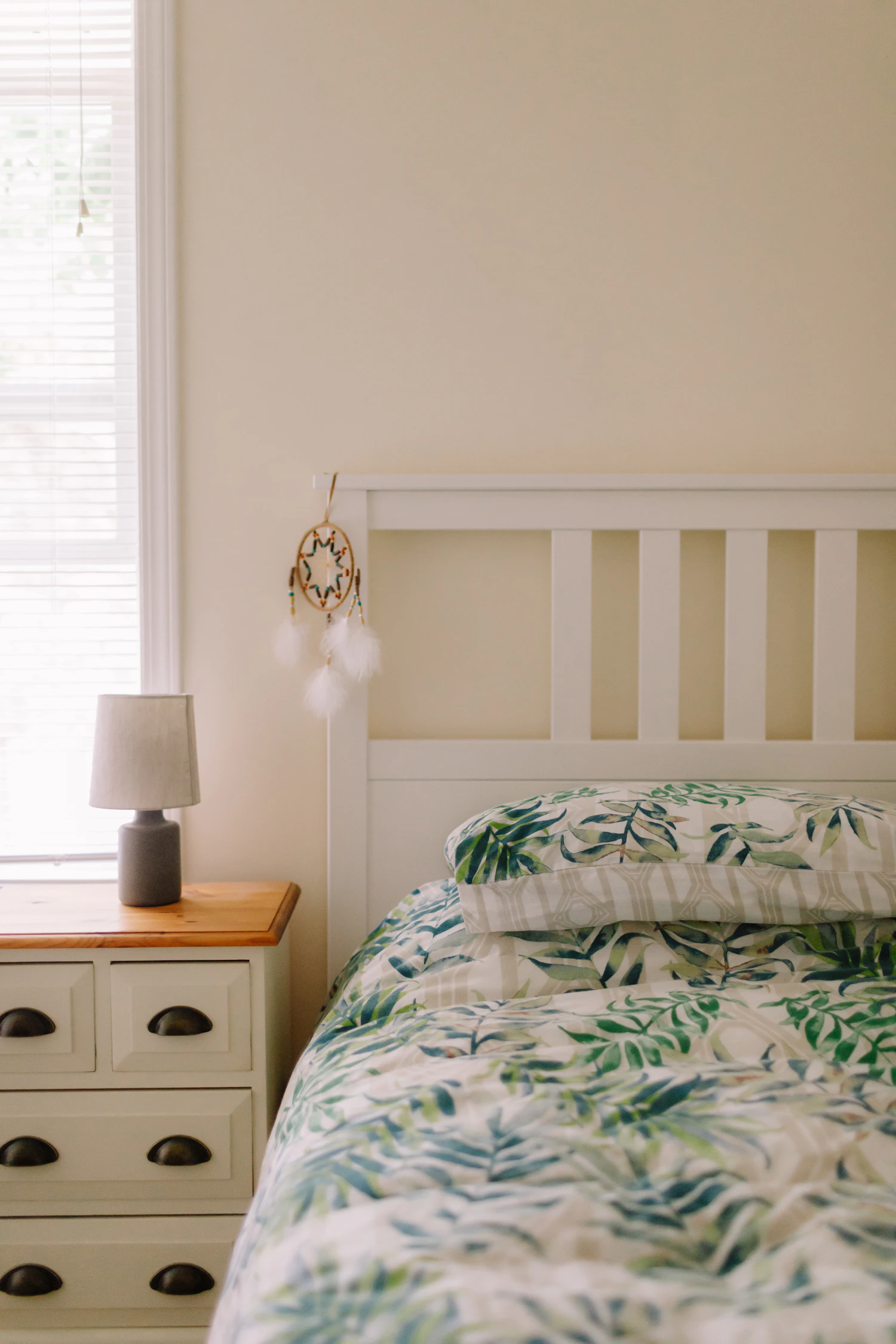 Made bed with green and white floral bedding showing pattern as the main visual layer