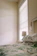 Cozy bedroom with modern decor and a large window letting in natural light.