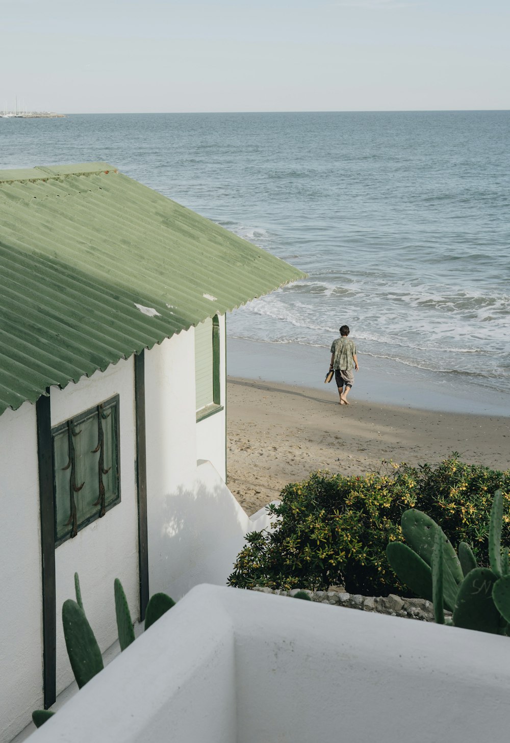 woman in white dress walking on beach during daytime