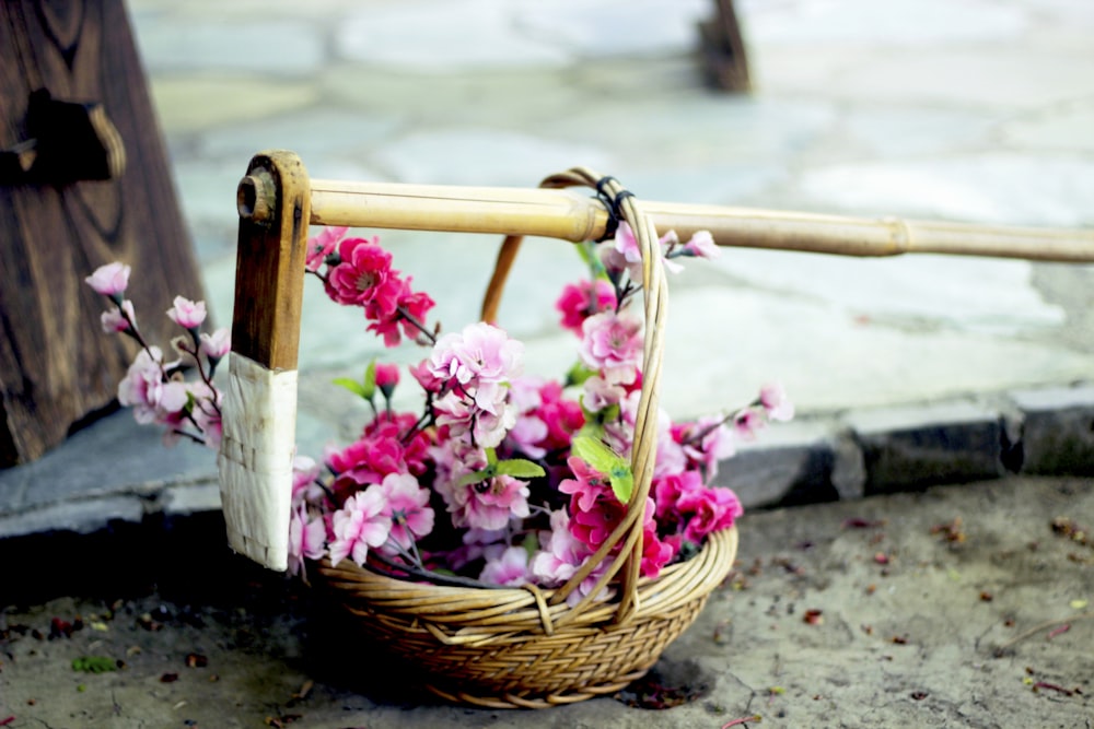 pink flowers in brown woven basket