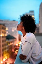 woman in white collared shirt looking at the city during night time