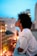 woman in white collared shirt looking at the city during night time