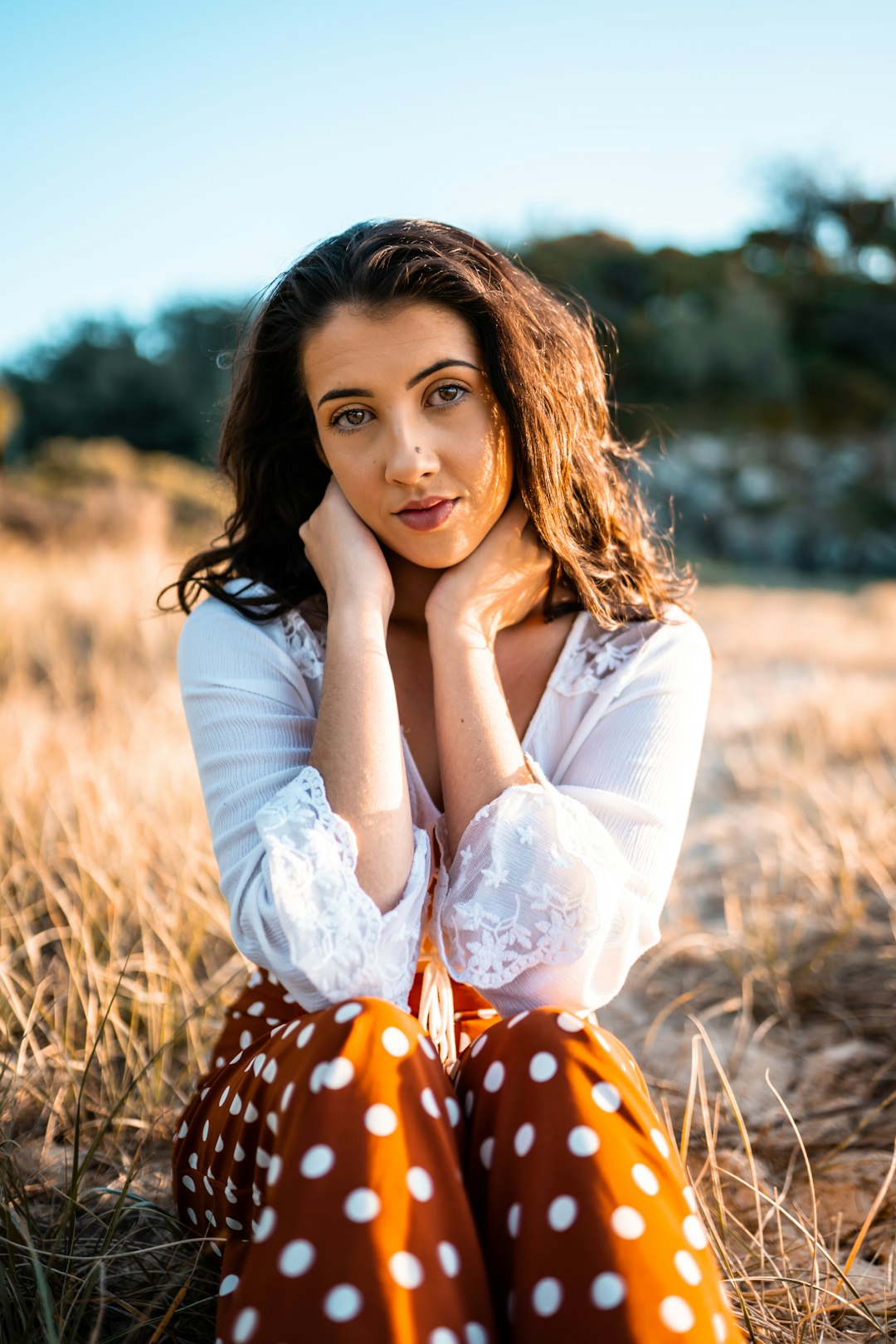 woman in white long sleeve shirt lying on brown grass field