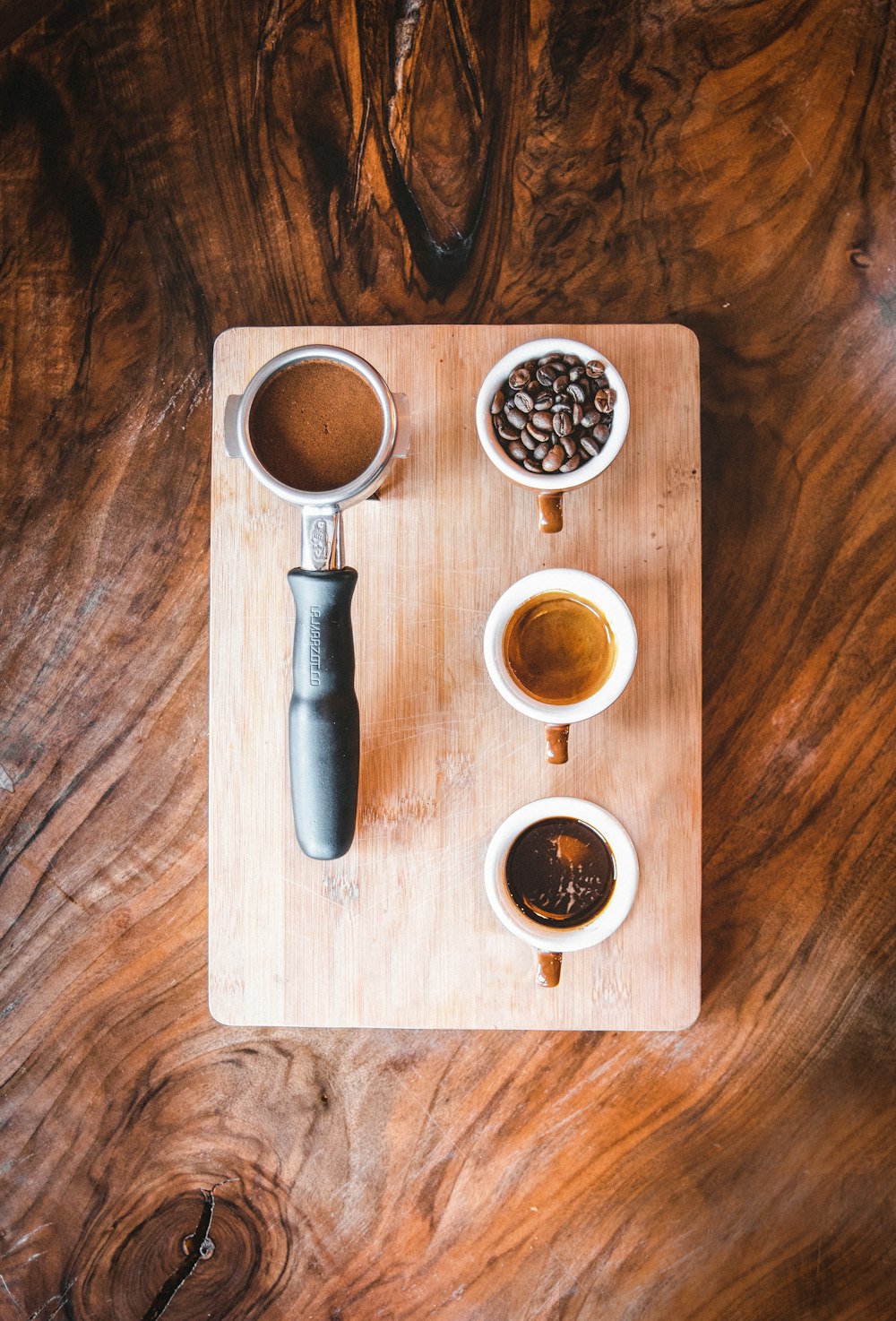 black bottle beside white ceramic mug on brown wooden table