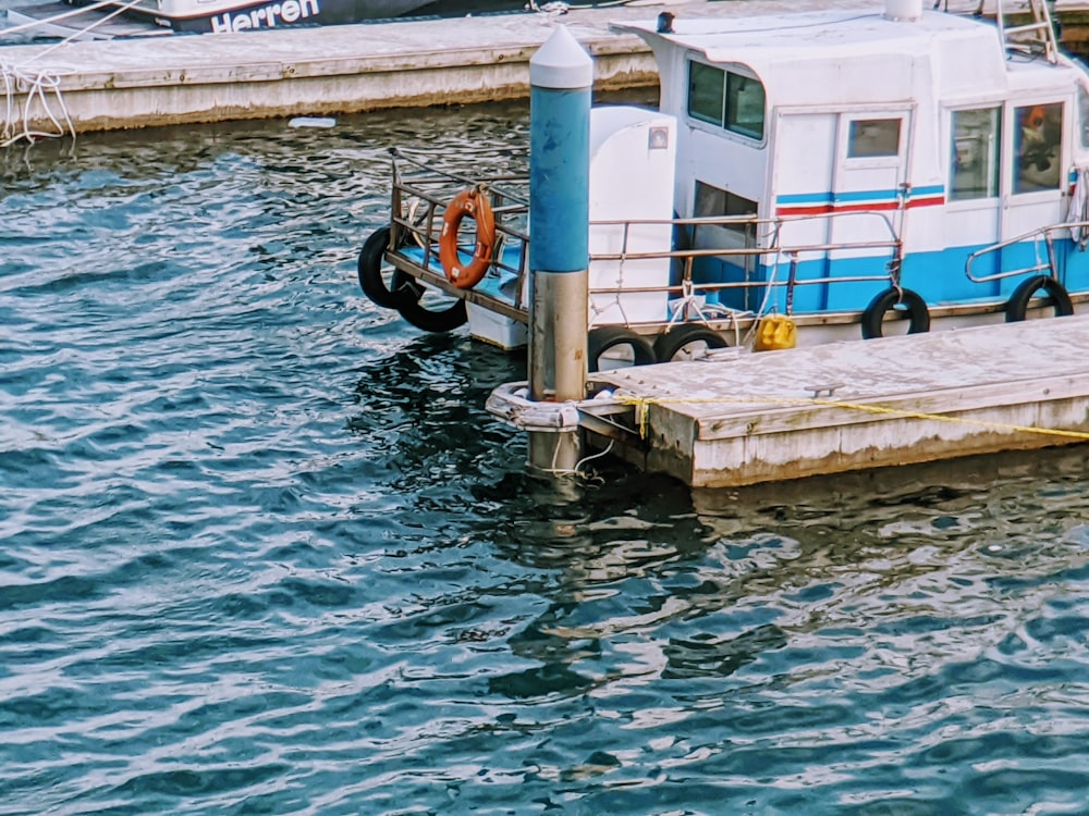 white and blue water pump on brown wooden dock during daytime