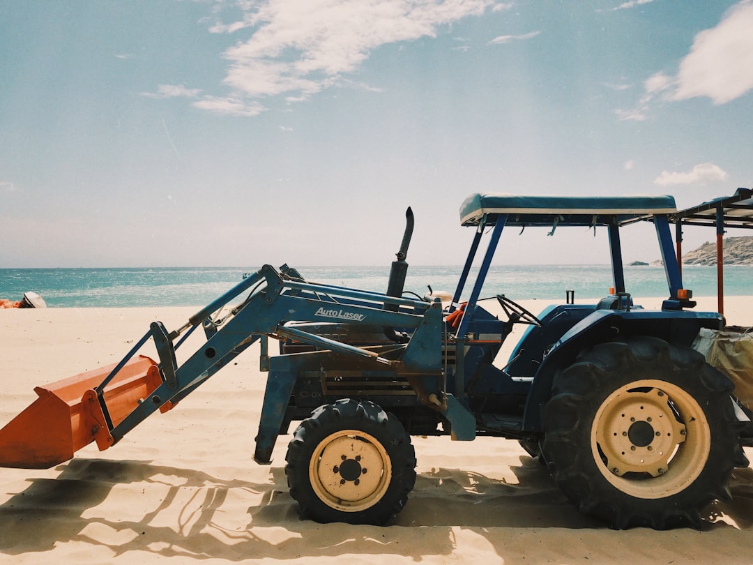 black and orange tractor on white sand during daytime