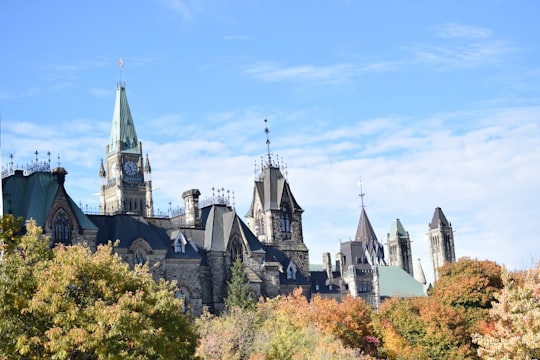 grey and black concrete castle under blue sky during daytime in Parliament Hill Canada