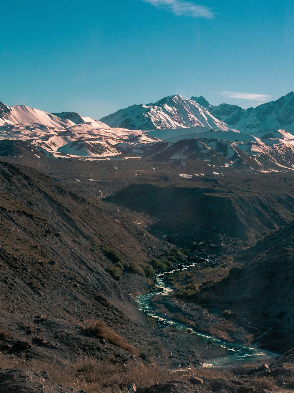 montagnes brunes et vertes sous ciel bleu pendant la journée