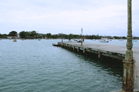 brown wooden dock on body of water during daytime in Armação dos Búzios Brasil