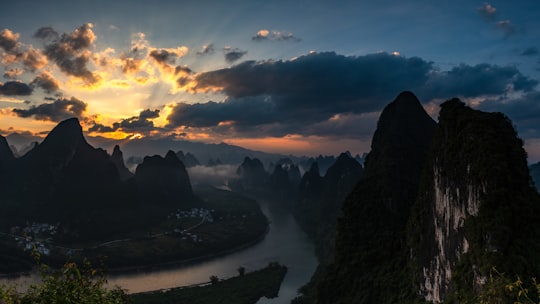 silhouette of mountain under cloudy sky during sunset in Yangshuo China