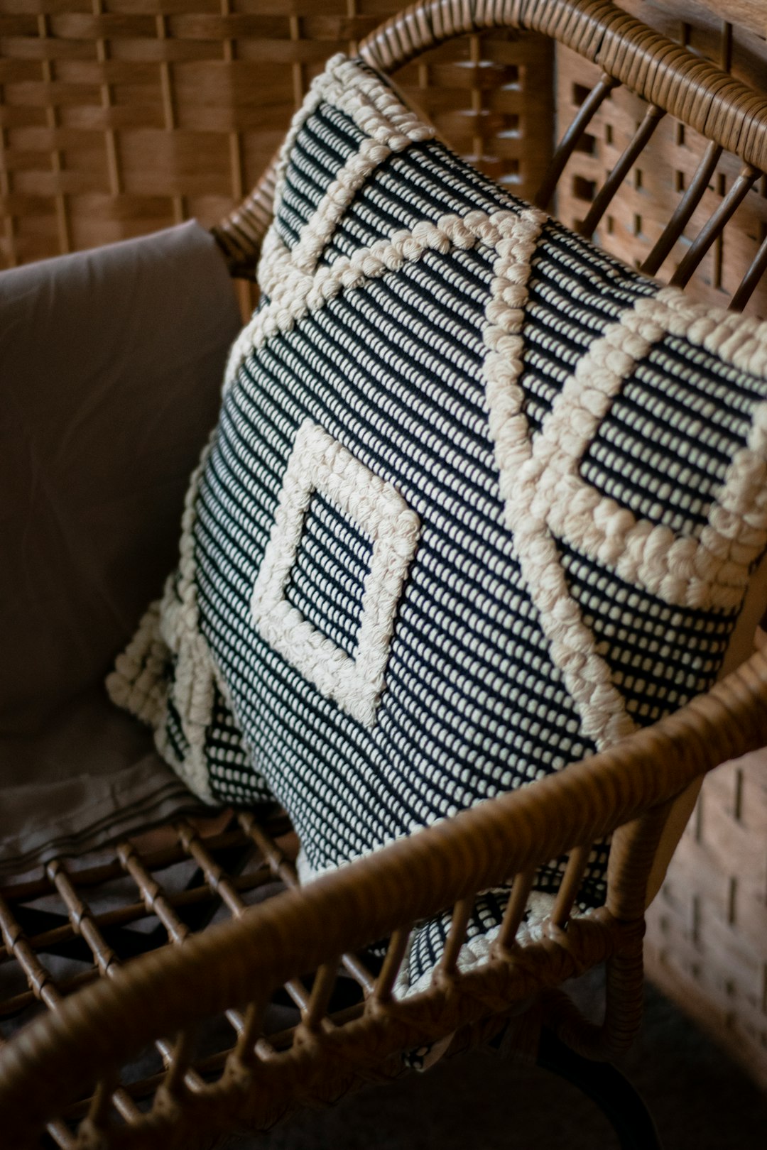 blue and white throw pillow on brown wicker armchair