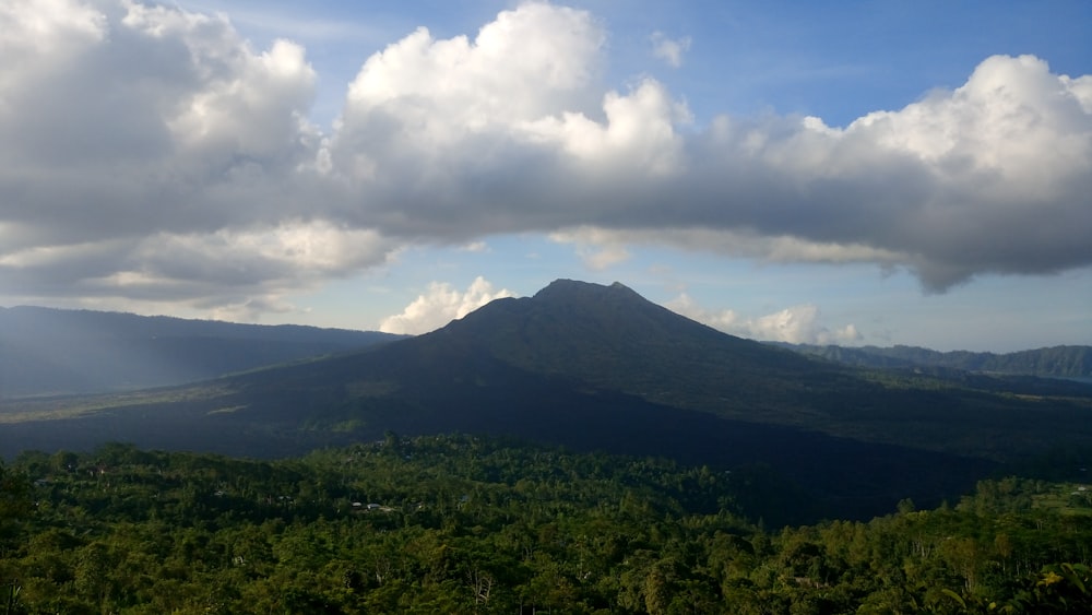 green mountain under white clouds during daytime