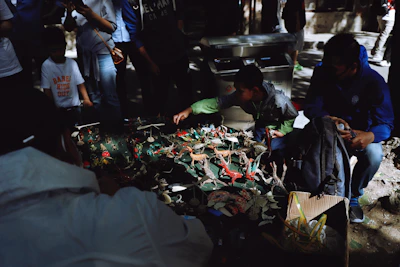 A vibrant display of rare collector's items arranged on a wooden table, with community members chatting in the background.