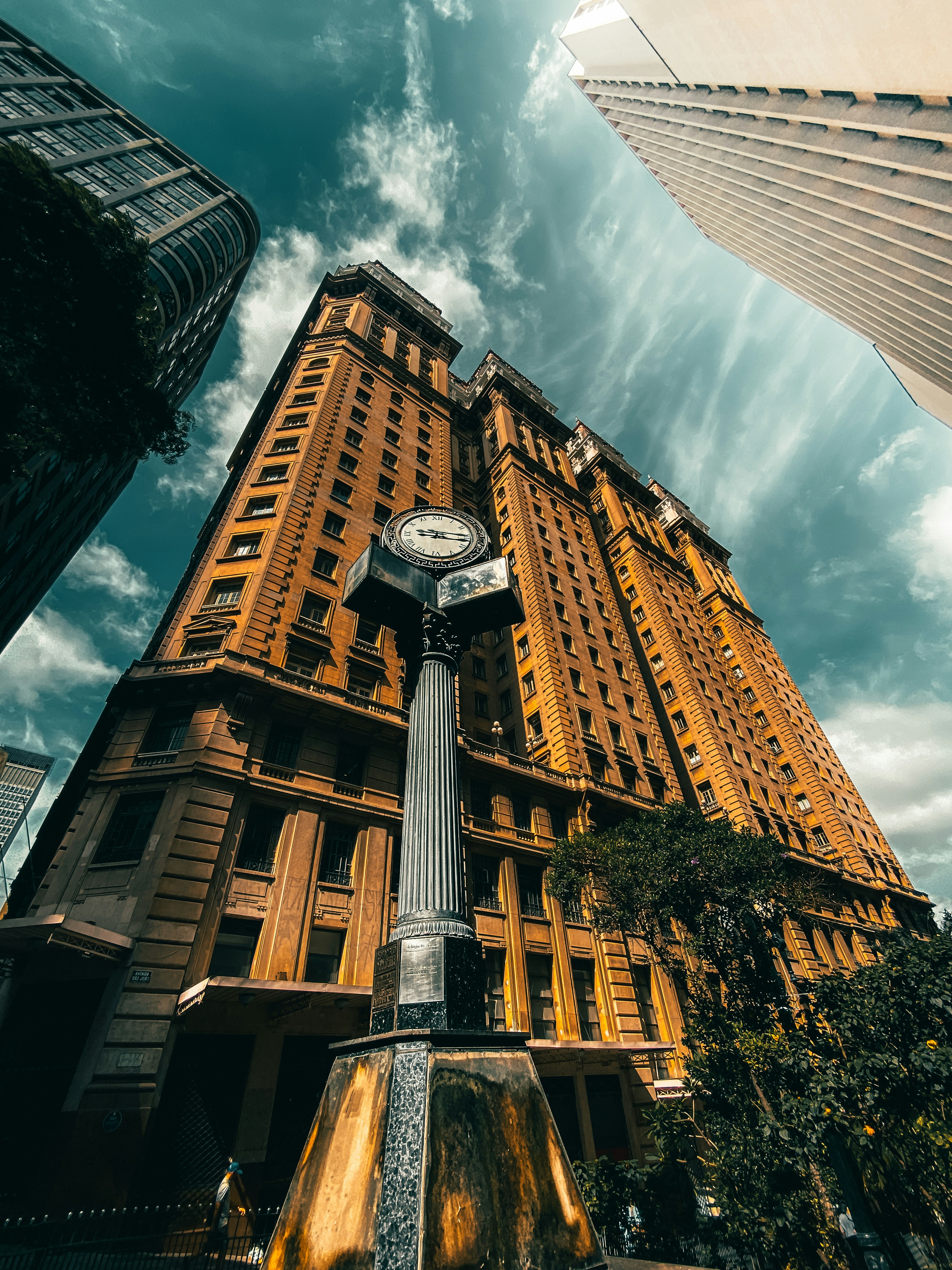 edificio in cemento marrone e bianco sotto nuvole bianche e cielo blu durante il giorno