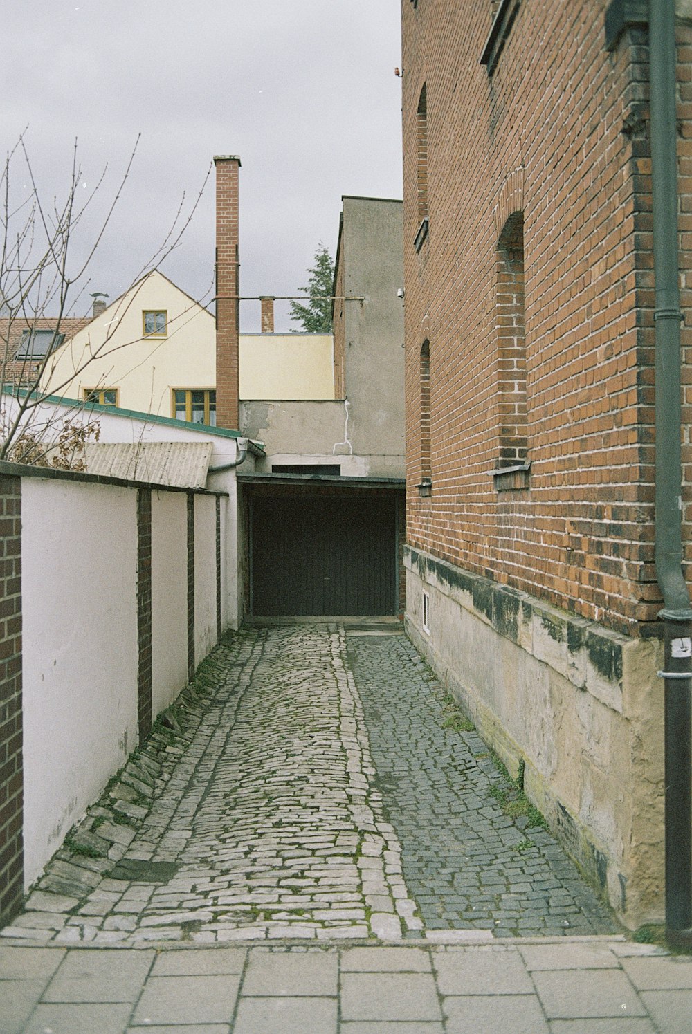 an alley way with a brick building and a fire hydrant