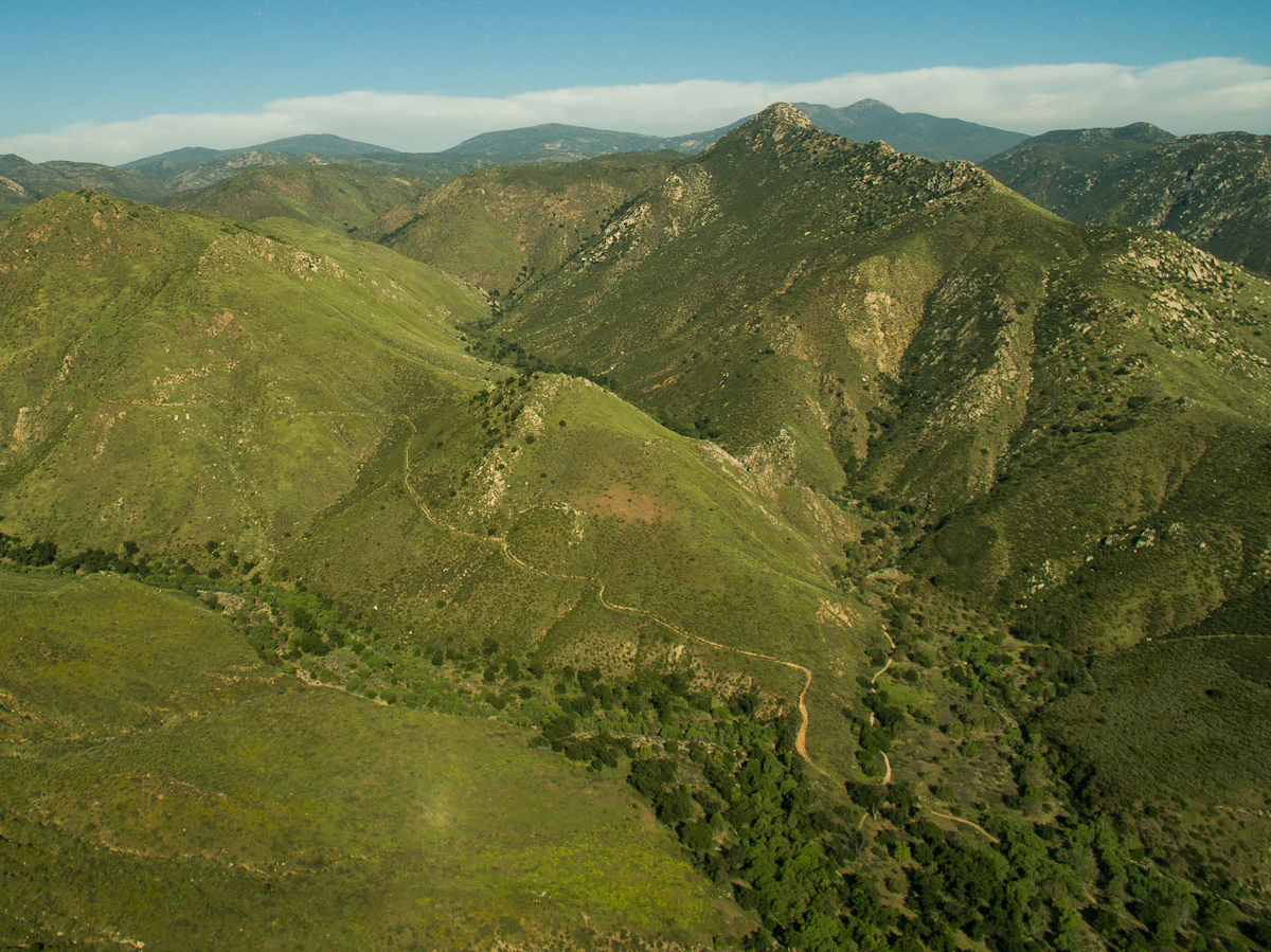 Green hills and dirt tracks near Cedar Creek Falls, outside Ramona, with higher ridges behind