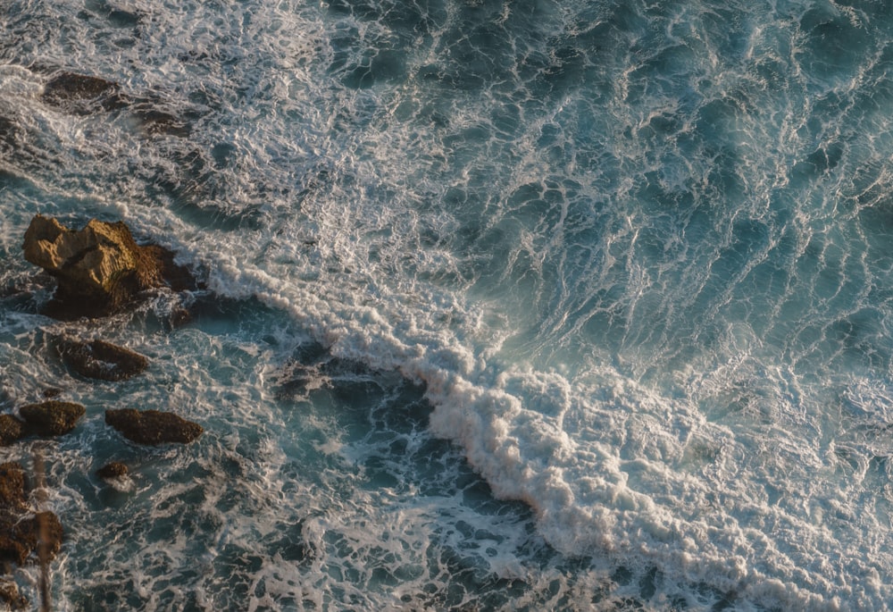 ocean waves crashing on shore during daytime