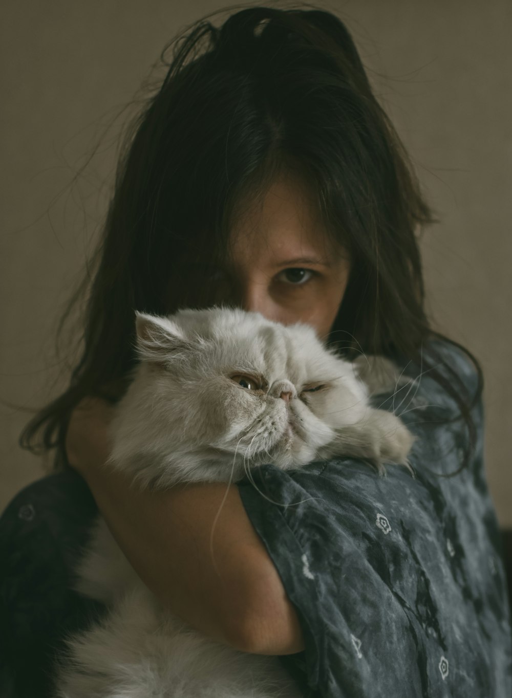 woman in black shirt holding white persian cat