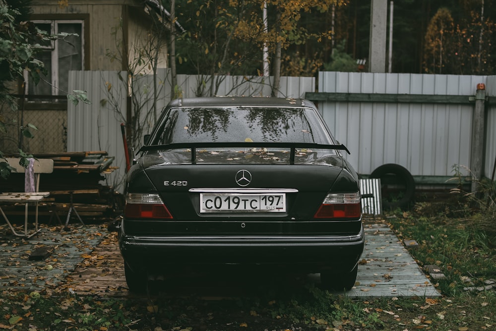 black audi a 4 parked near white wooden fence