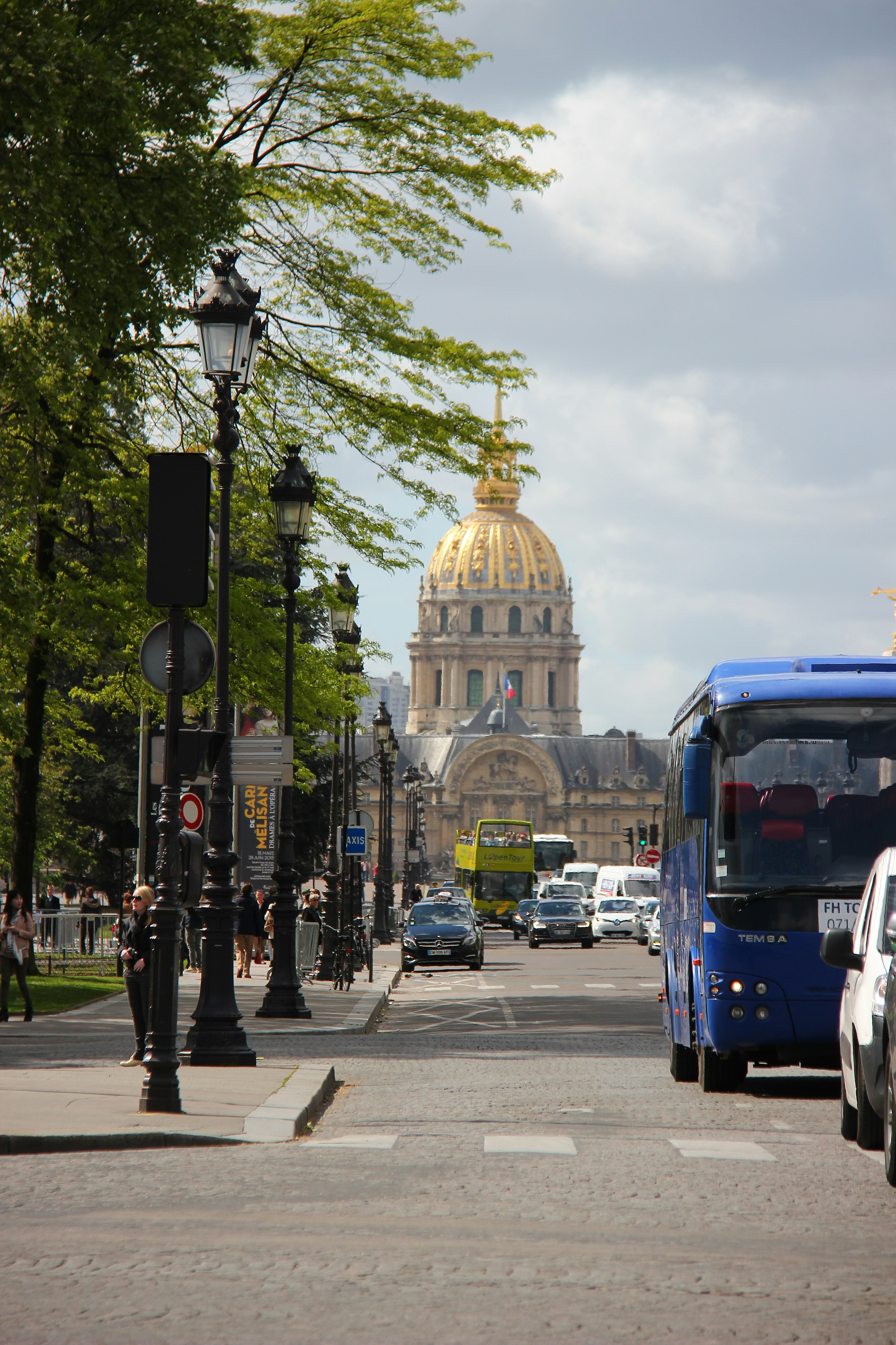 blue bus on road near white concrete building during daytime