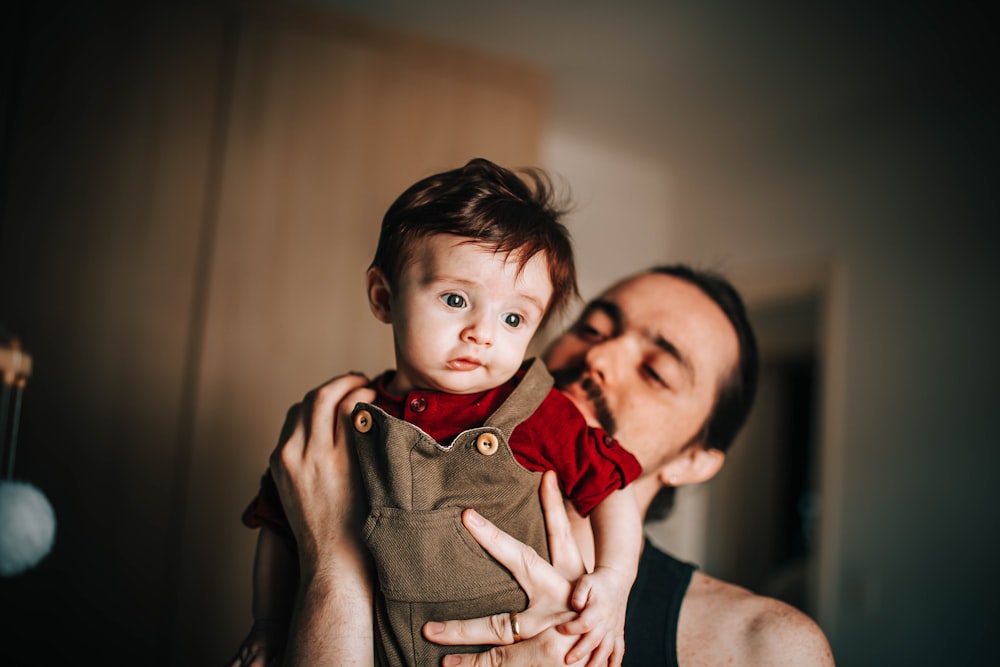 woman in black tank top carrying child in brown button up shirt