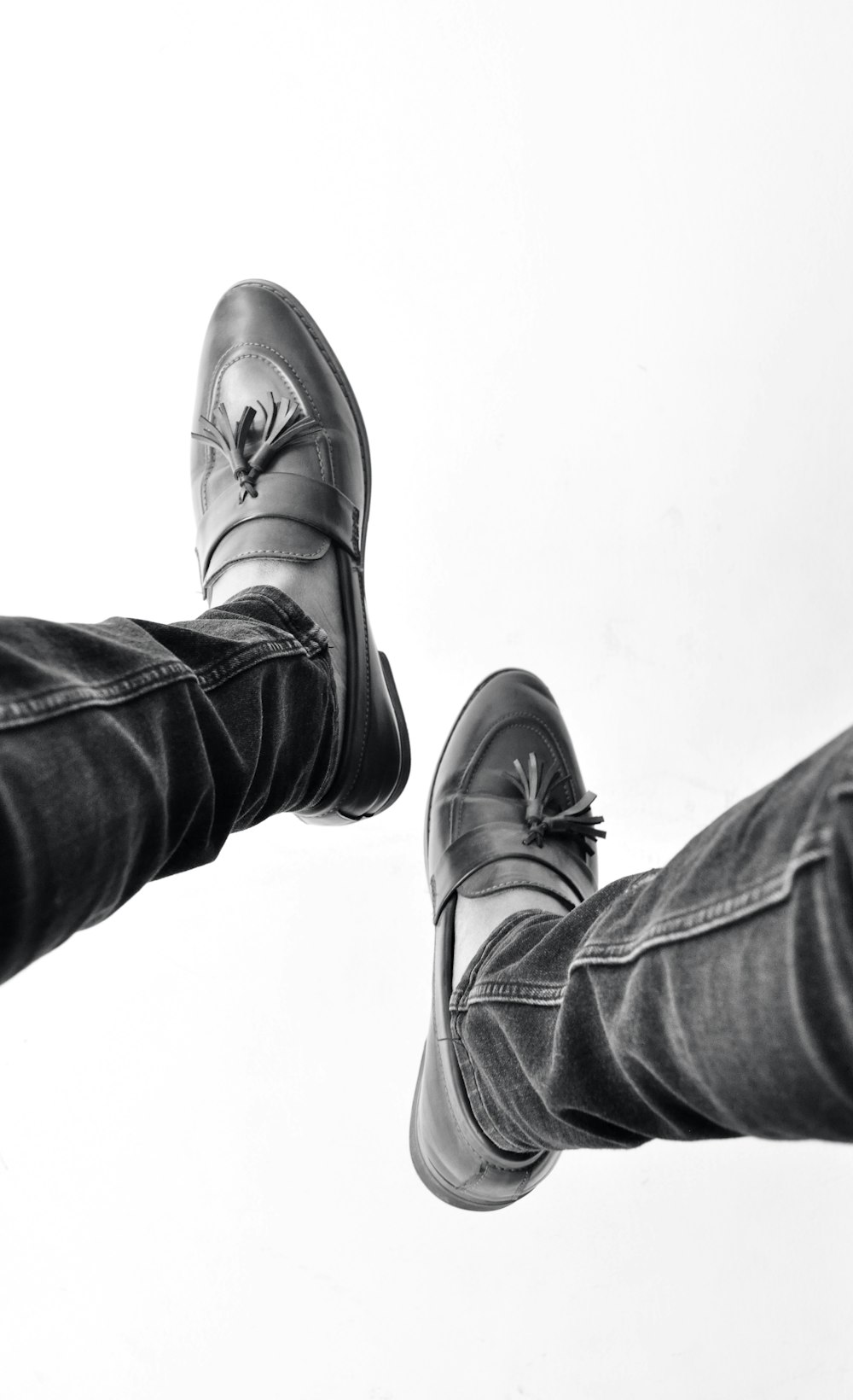 person in black denim jeans and black leather shoes