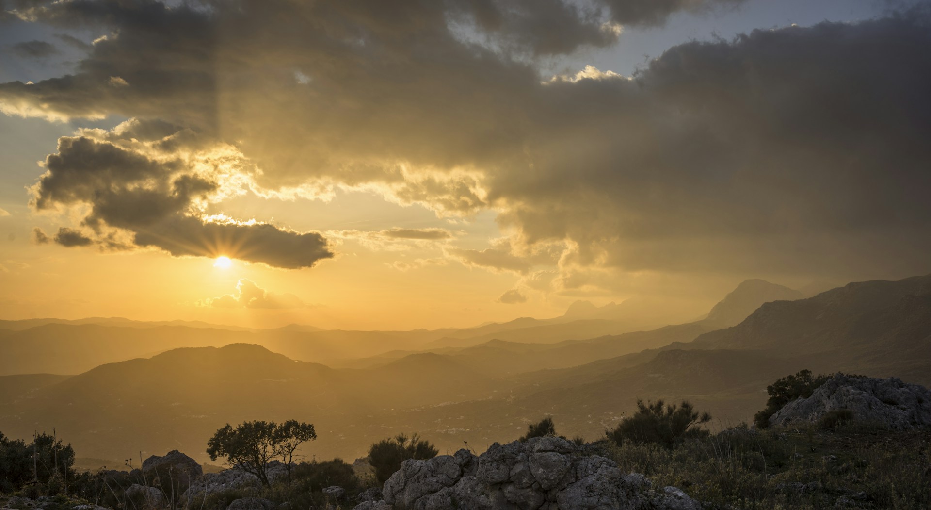 the sun is setting over a mountain range