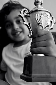 Close-up of a smiling girl student proudly holding her scholarship award at a dnyangandh event.