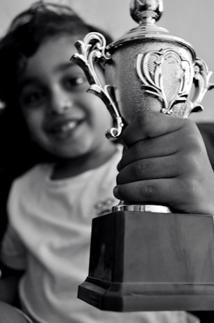 A student proudly holding a certificate after clearing an Olympiad exam.