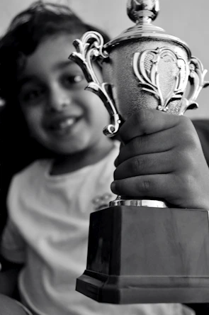 Excited kids proudly holding trophies at a spirited chess tournament.
